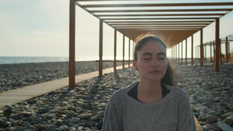 Mujer meditando en la playa al atardecer