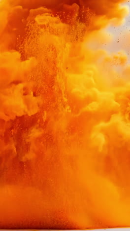 a large orange cloud of smoke is billowing out of a fire. the smoke is thick and billowing, creating a sense of chaos and destruction. the orange color of the smoke contrasts with the gray background