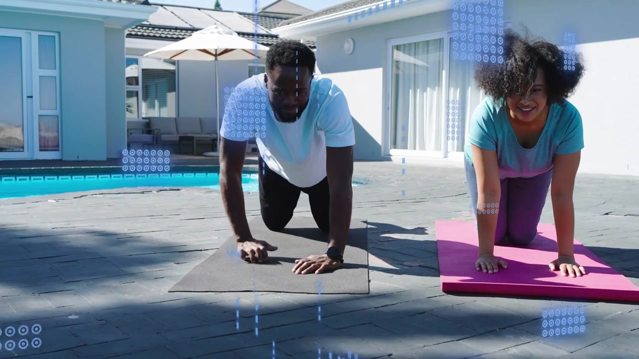 After positioning hands on mats, woman and man moving into plank at poolside for fitness demo