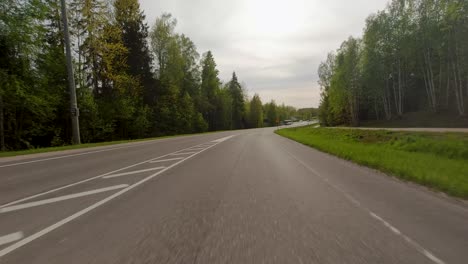 Cars-navigate-through-a-roundabout,-surrounded-by-trees,-on-the-road