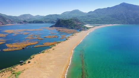 river estuary separated from mediterranean seaside by narrow white sand spit beach