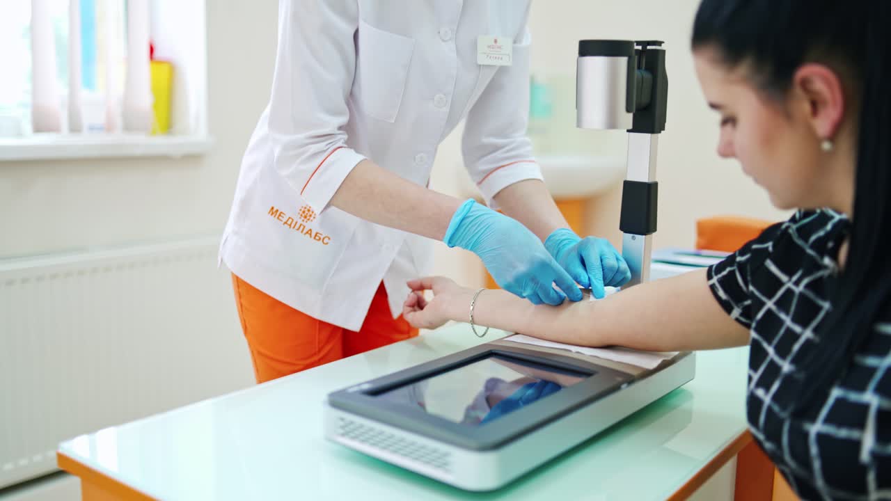 Donor giving blood. Nurse taking blood from the patient's arm. Female worker takes analysis from vein in the modern laboratory.