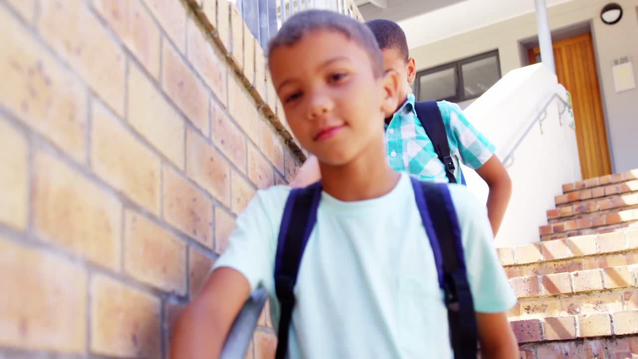 escolares sonrientes caminando por las escaleras de la escuela