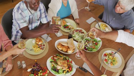 happy senior diverse people having dinner at retirement home