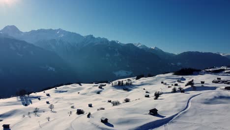 Bright-afternoon-sunlight-shines-on-rolling-countryside-with-snow-in-Alps