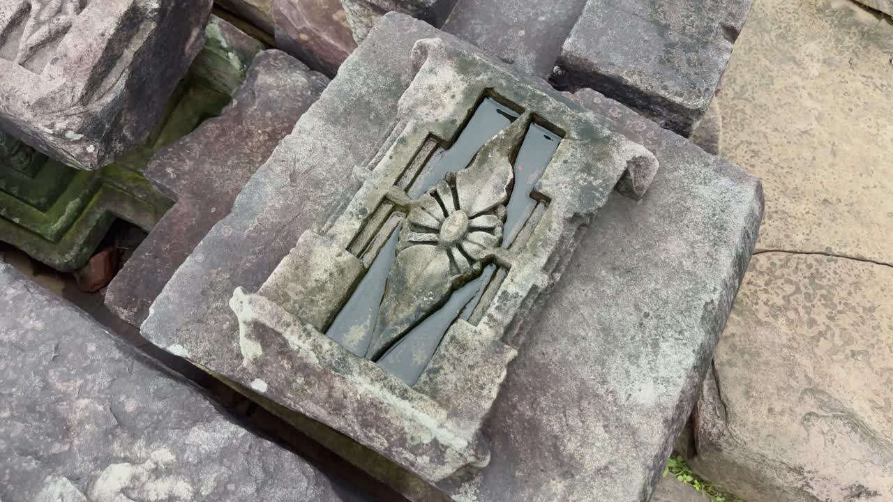 As the camera spins around, a carved stone block with a lotus motif comes into focus, symbolizing purity and enlightenment, showcasing the intricate artistry of ancient Buddhist stonework