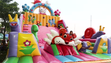 children playing on colorful inflatable slide