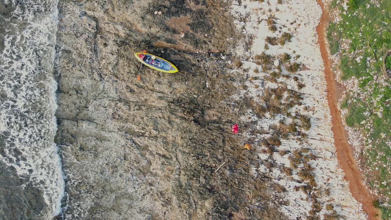 Aerial View of Kayak and People on a Rocky Coastline