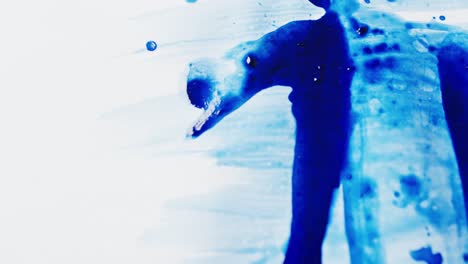 Close-up-of-blue-paint-shapes-on-white-background-with-copy-space,-slow-motion