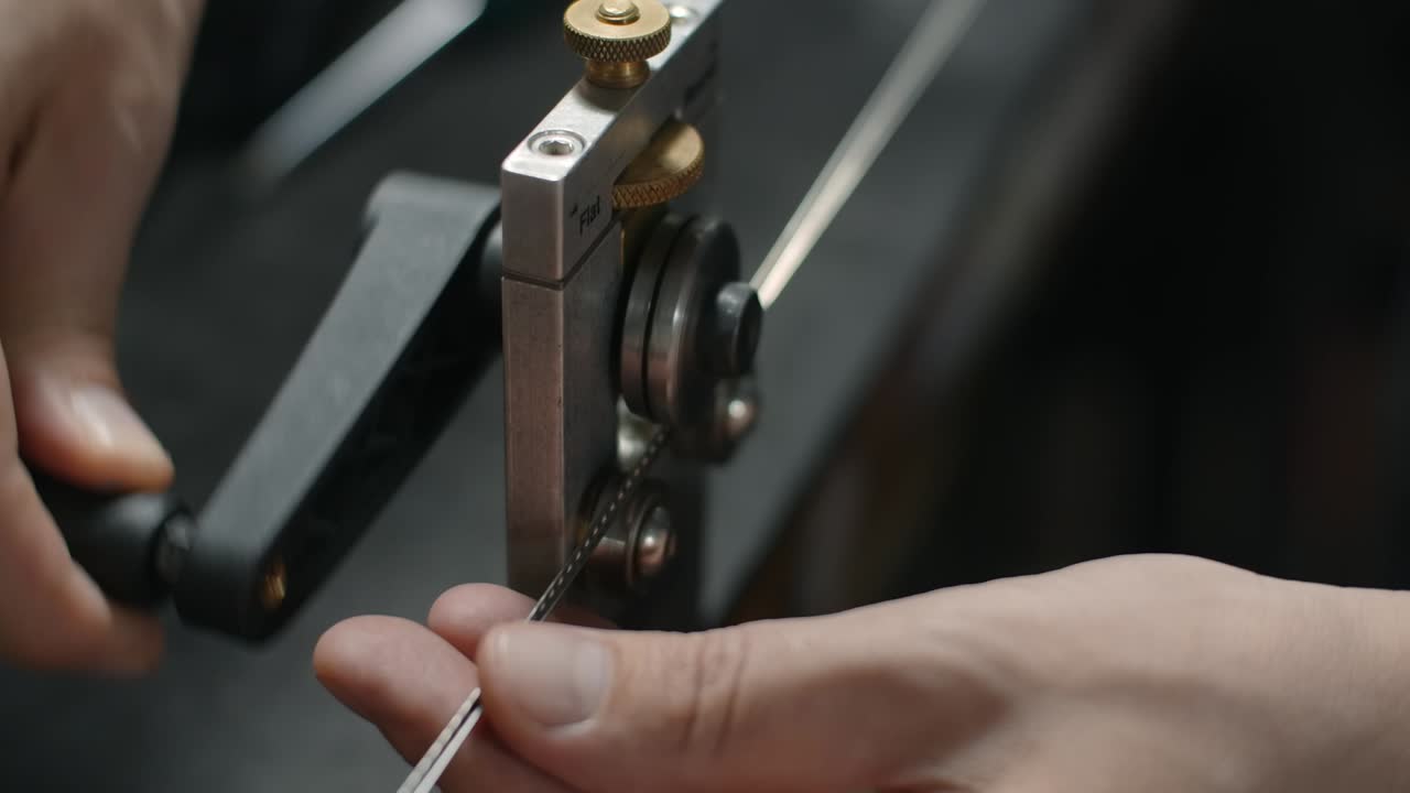 лютиер использует фретбендер для настройки радиуса провода фрета, подготовка для фретинга в мастерской гитарного производителя, 4k 60p prores hq
