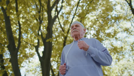 anciano atleta abuelo corriendo corriendo en el parque soleado durante el entrenamiento matutino cardio al aire libre