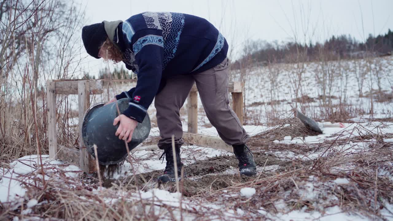 Man Pouring Earth Fill On The Ground In Winter