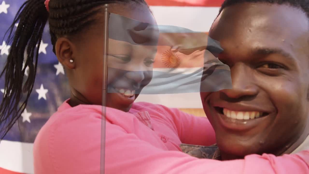 Animasjon av USAs flagg som vaier over en smilende afroamerikansk far og datter som omfavner hverandre.