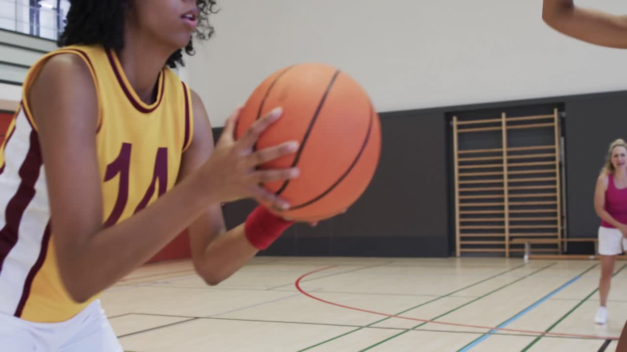 entrenamiento de un equipo de baloncesto femenino diverso en una cancha cubierta, en cámara lenta