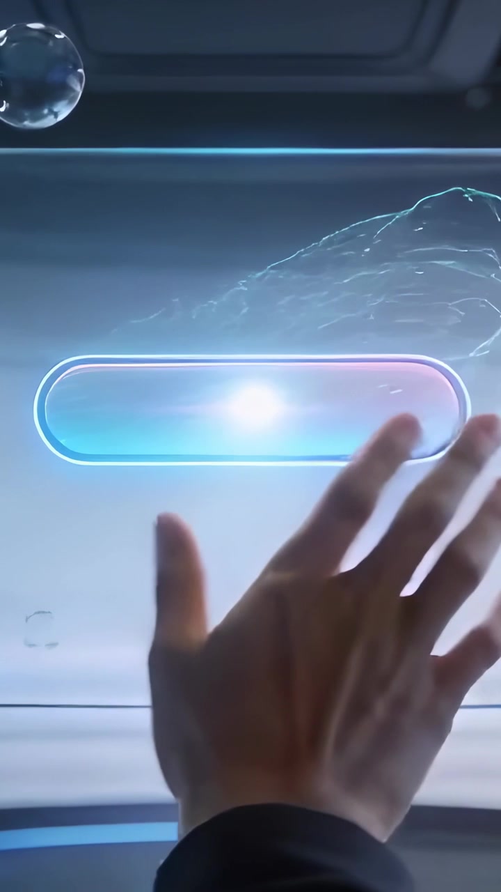 Video verticale: Una mano destra con un polsino scuro preme su un display trasparente dell'auto, accendendo una capsula luminosa.