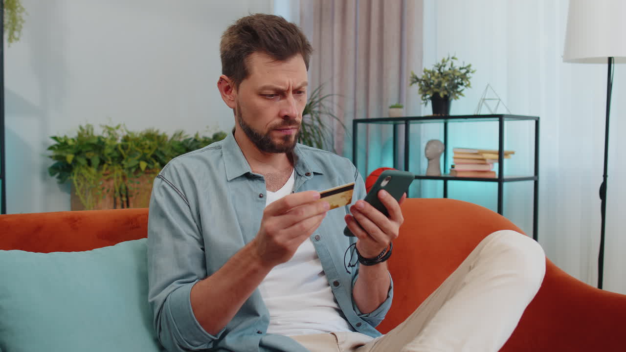 hombre guapo usando tarjeta de crédito y teléfono inteligente, transfiriendo dinero, comprando compras en línea