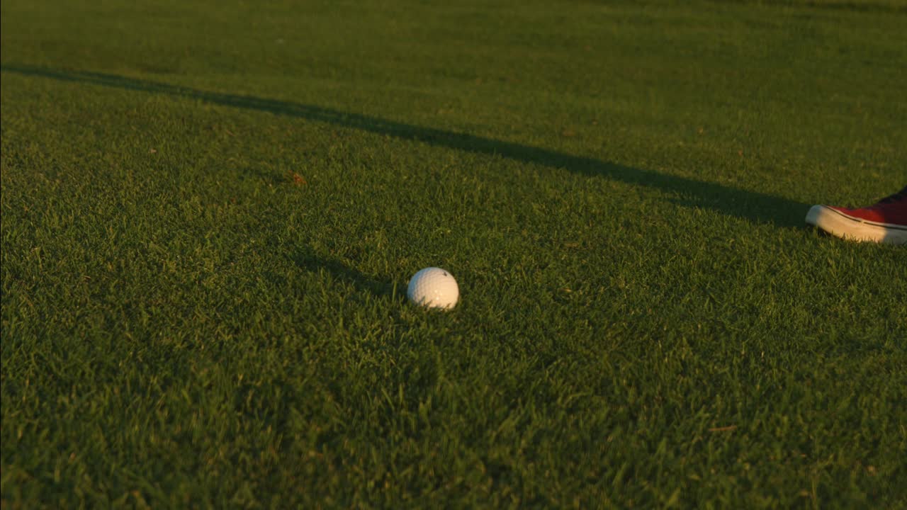 골프 코스에서 공으로 샷을 하는 골퍼