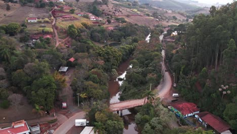 toma aérea del campo en un día soleado moviéndose sobre un río que muestra bandadas de pájaros volando a través del cañón