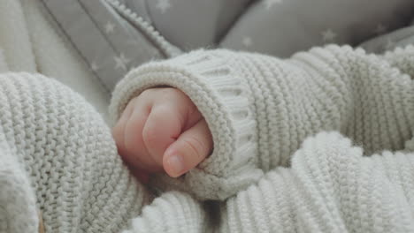 baby's hands in knitted sweater