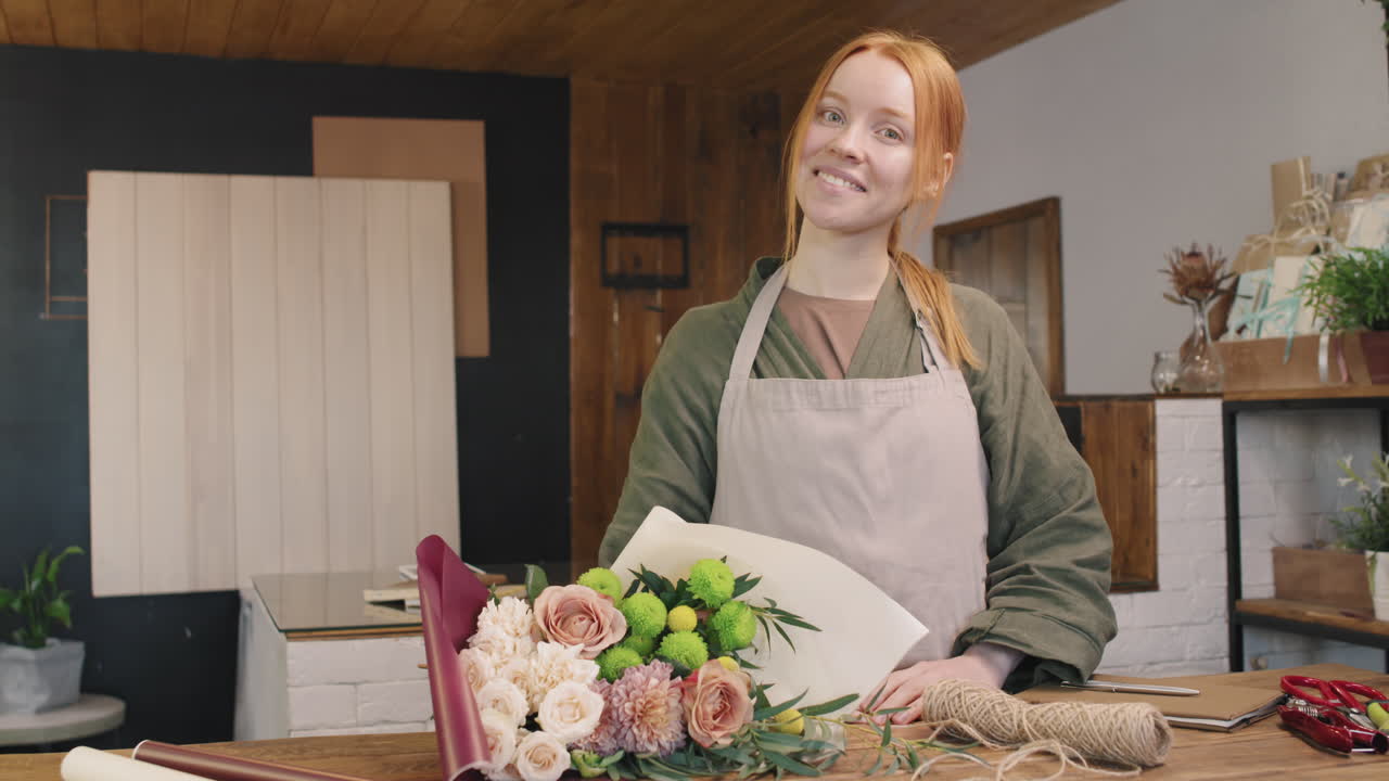 Ritratto di fiorista sorridente con un mazzo di fiori composto