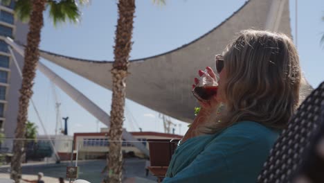 wealthy blonde woman drinking lying in a resort. slow motion