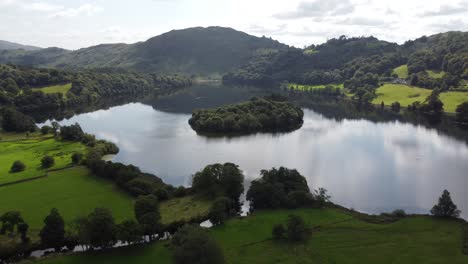 Drone-View-Grasmere-Cumbria-Inglaterra-4k-Nubes-Y-Cielo-Azul-Reflejado-En-La-Superficie