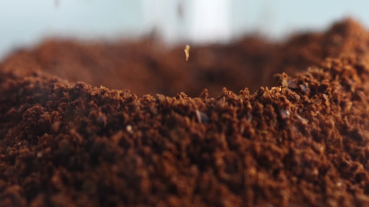 Primo piano di caffè macinato che cade su una pila, ricca texture e aroma