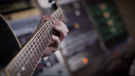 fotografía de cerca de un guitarrista de bajo tocando un instrumento en un estudio de grabación