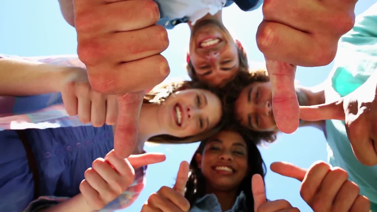 학생 들 이 머리 를 함께 놓고 엄지 손가락 을 카메라 에 올리고 있다