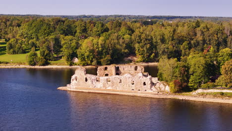 aerial at sunset of koknese castle ruin complex in koknese, latvia, situated on a high bluff overlooking the daugava river valley drone footage