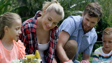 Family-gardening-with-flower-pots-sitting-on-grass