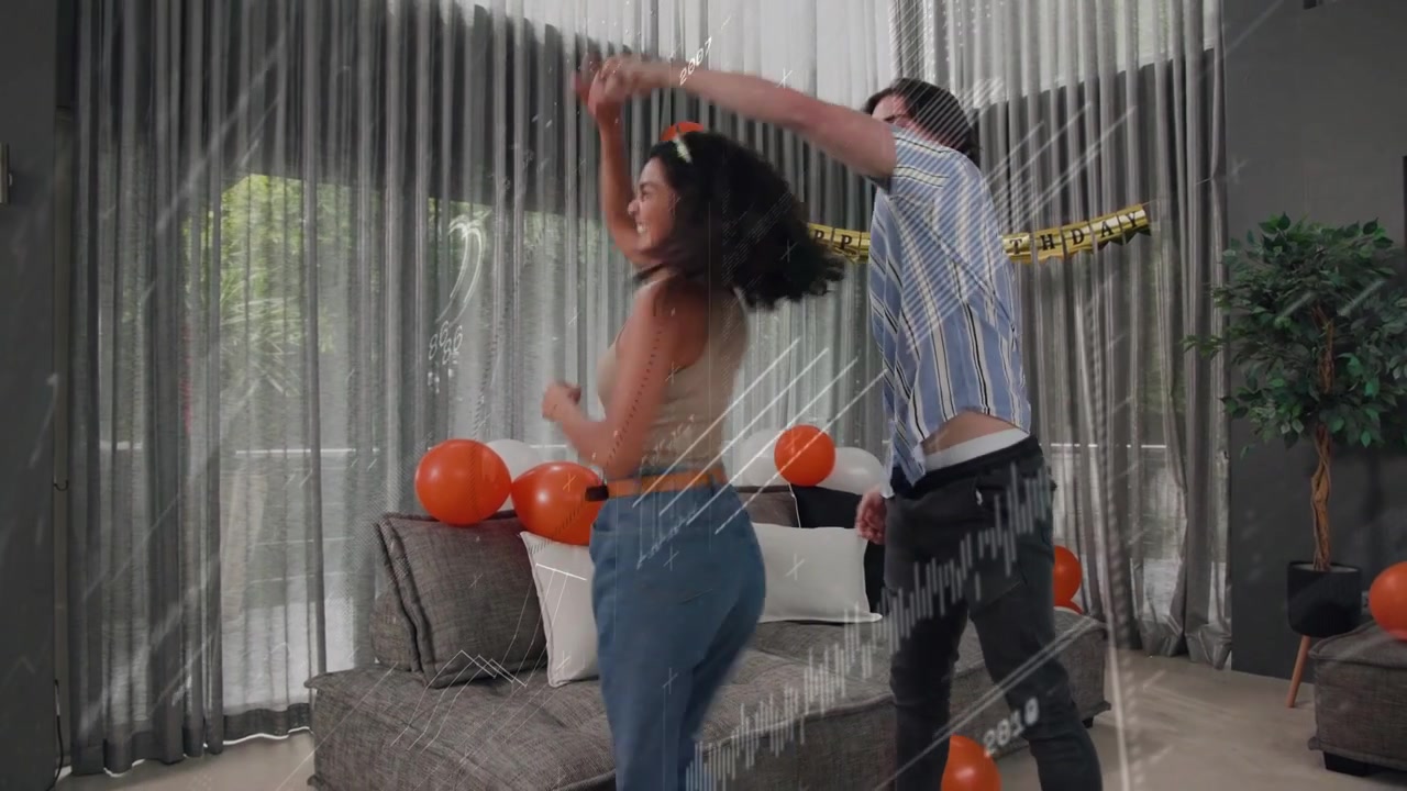 Man and woman taking hands, celebrating and dancing in living room, balloons shifting under overlay