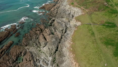 Tilt-Reveal-of-a-Coastal-Headland-in-North-Devon-on-a-Summer’s-Day