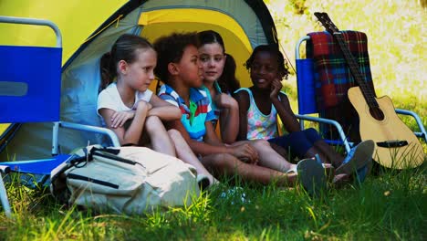 kids interacting with each other outside tent at campsite