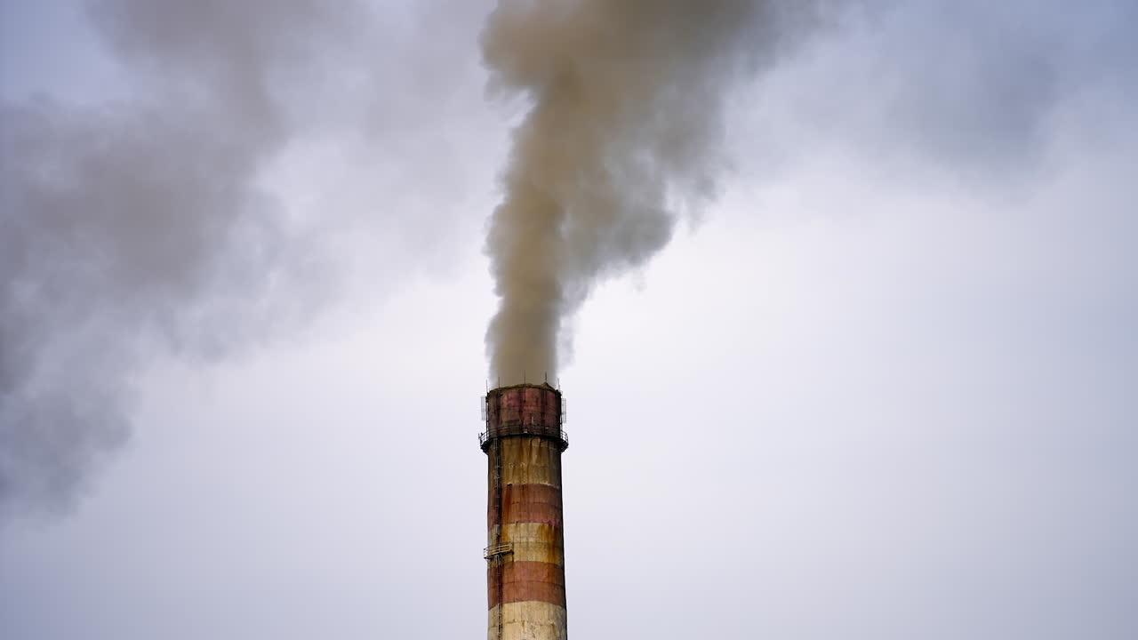 Smokestack exhausting combustion gases into the air. Dense smoke from pipes pollute the atmosphere. Dangerous emissions in the sky. Climate change.