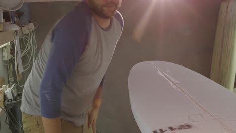 un hombre que hace tablas de surf en su taller