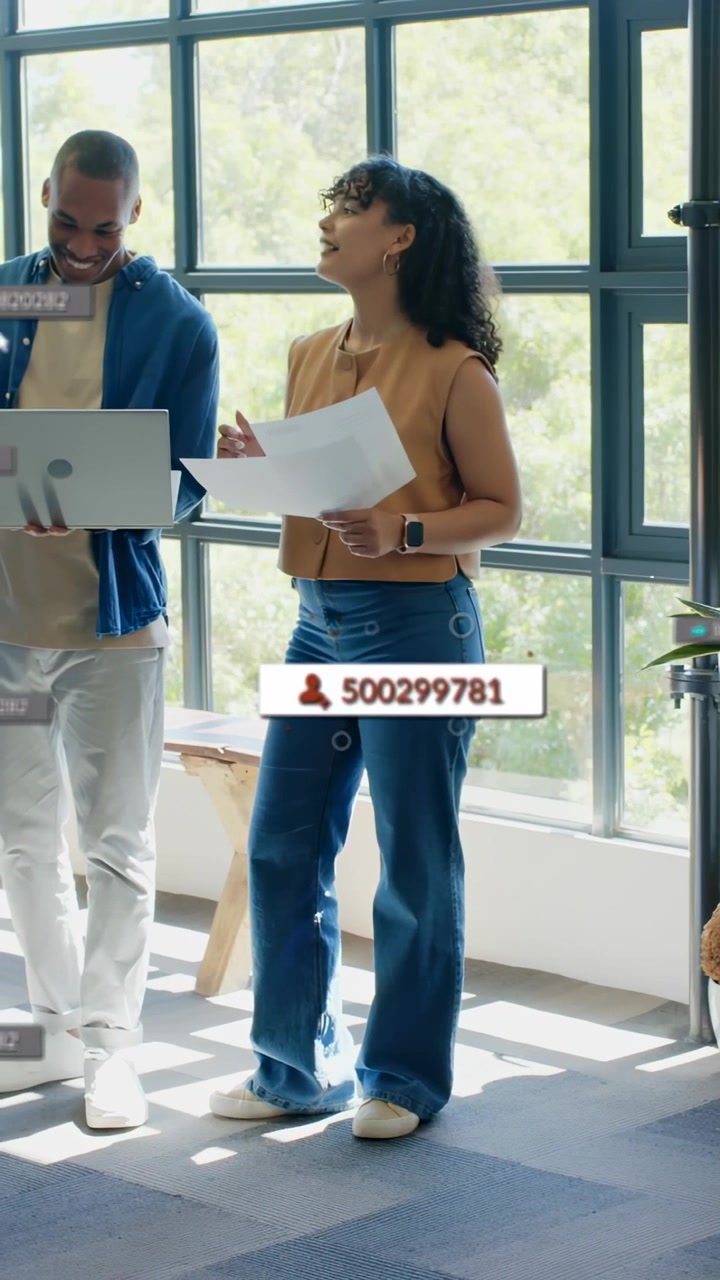 Donna che tiene delle pagine e si gira verso un uomo che mostra un laptop, leggendo in una riunione di lavoro con UI fluttuante