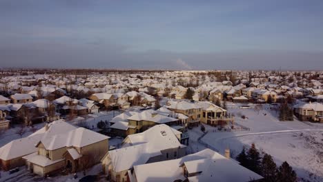 Toma-De-Drones-De-Las-Casas-Cubiertas-De-Nieve-Durante-La-Puesta-De-Sol-De-La-Hora-Dorada