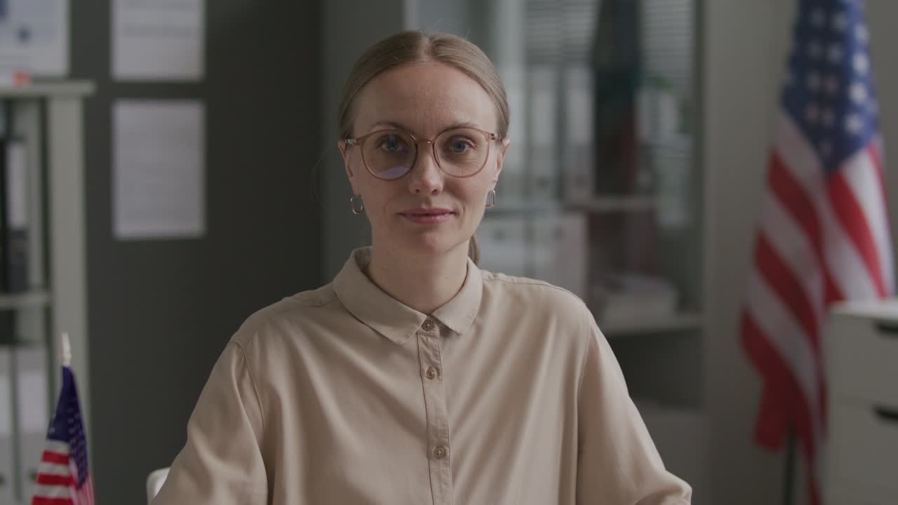 Portrait of Visa Officer Sitting at Desk with Laptop in American Embassy