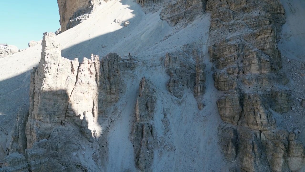 Filmagens aéreas de drone de Tofana di Rozes, Itália: imponentes falésias de calcário, cristas rochosas e espetacular paisagem das Dolomitas sob um céu limpo. Ideal para projetos de natureza, viagens e atividades ao ar livre