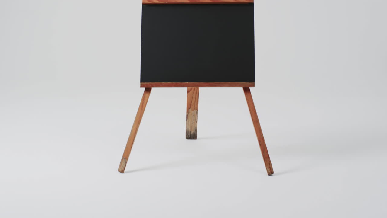 video de un letrero de pizarra en un soporte de madera con espacio de copia en un fondo blanco