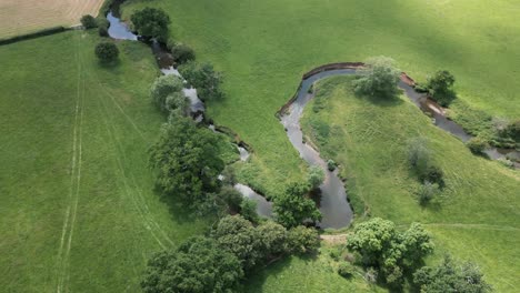 Eine-Luftaufnahme-Des-Winzigen-Flusses-Arrow,-Der-Sich-Seinen-Weg-Durch-Die-Landschaft-Von-Warwickshire,-England,-Schlängelt