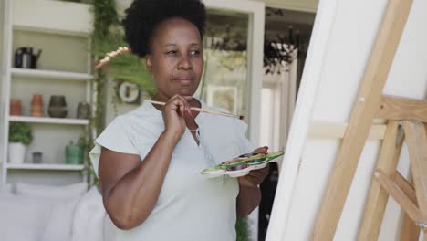 focused senior african american woman painting in slow motion