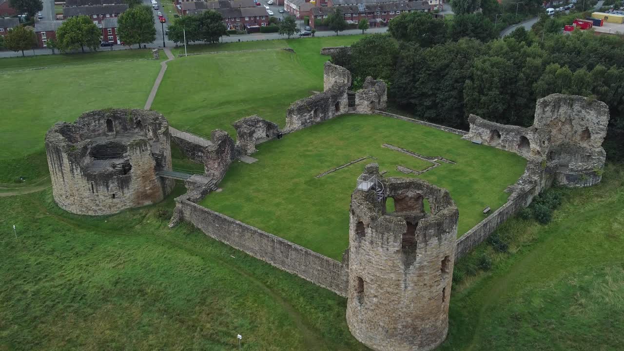 castillo de pedernal galés medieval costero militar fortaleza ruina vista aérea seguimiento lento tiro de arriba hacia abajo