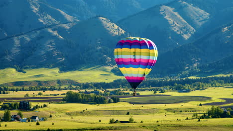 Hot-Air-Balloon-Landing-in-Mountains-at-Sunrise---Close-Aerial-View
