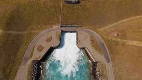 turquoise water spilling violently into hydro canal at lake pukaki