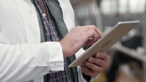 hands of man using tablet at cattle farm