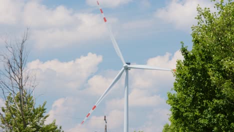 Big-wind-turbine-generates-green-electricity-on-a-beautiful-summer-day,-slider