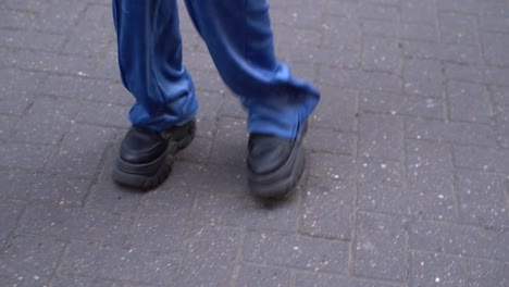 Feet-with-sneakers-of-a-young-woman-as-she-jumps,-skips,-and-turns,-close-up