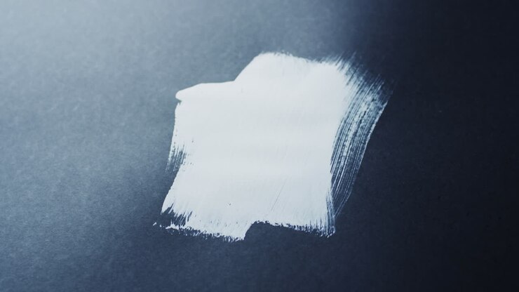 Close up of white paint shapes on black background with copy space, slow motion
